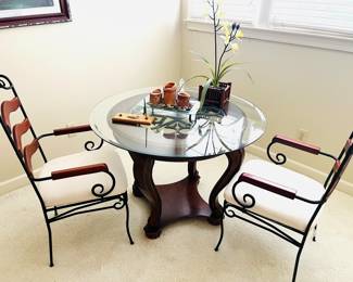 Glass top dining table with two metal and wood ladder back chairs