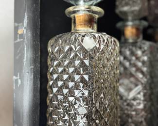 Vintage cut glass decanter with a diamond pattern and a square stopper. Its intricate design and clear glass are perfect for spirits.