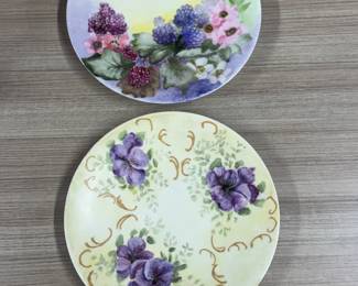The plates marked "J.P. L. France" were produced by Jean Pouyat in Limoges, France, between 1890 and 1932. These pieces are known for their hand-painted floral designs, typical of the high-quality porcelain from this region during that period.