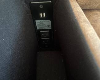 Arm rests open for storage and one side hosts usb port and electric outlet 
