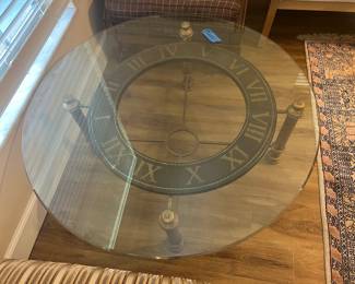 Gorgeous glass top coffee table sits on a bronze looking 4 leg stand with Roman Numbers.