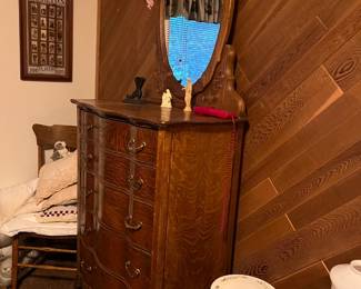 Here we are showing another dresser, taller this time, with an integrated oval mirror.  There is a rocking chair in the corner.