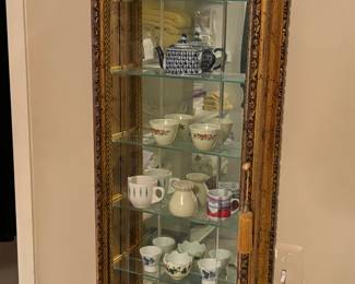 Gold display case, tea cups and tea pot