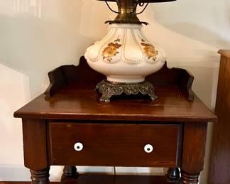 Side table with shelf and drawer, holding a double bulb lamp 