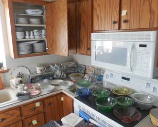kitchenware and vintage colored glass. Set of dishes in cupboard