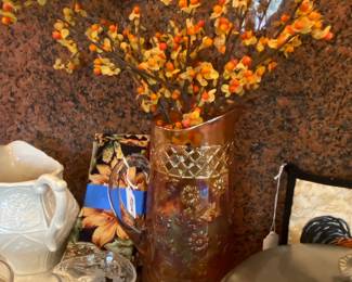 Large marigold carnival glass pitcher filled with bittersweet