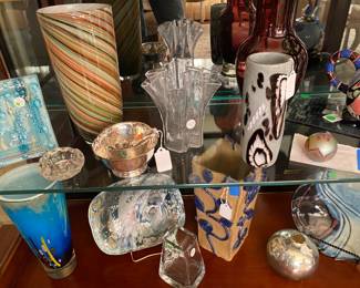 Two shelves of art glass and art pottery