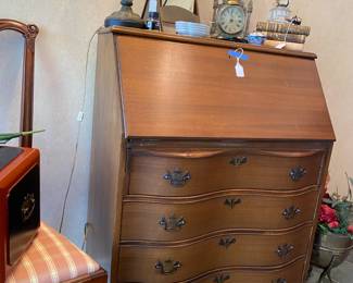Nice 4 drawer desk with antiques arrayed on top