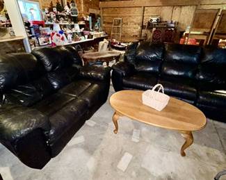 Black leather reclining sofa & loveseat, oval wooden coffee table