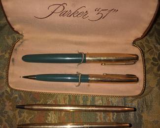 CLOSE UP VIEW OF A 1951 PARKER PEN SET WITH ORIGINAL CASE AND A CROSS PEN AND PENCIL SET.