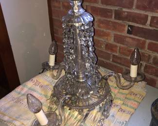 FULL VIEW OF ANTIQUE WATERFORD CRYSTAL CHANDELIER WITH ALL OF THE CRYSTAL PRISMS. THREE LIGHTED ARMS