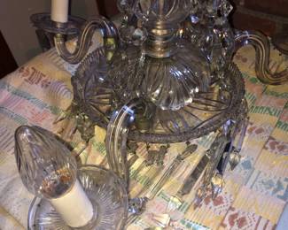 CLOSE UP VIEW OF ANTIQUE WATERFORD CRYSTAL CHANDELIER WITH ALL OF THE CRYSTAL PRISMS. THREE LIGHTED ARMS