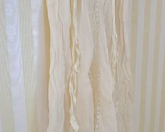 No, it's not an optical illusion, there is actually a beautiful little antique baby dress there.