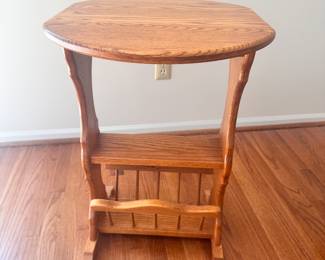 Oval oak end table with bottom magazine rack.