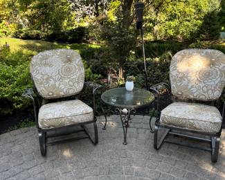 Two wrought iron garden chairs with cushions and  round table.