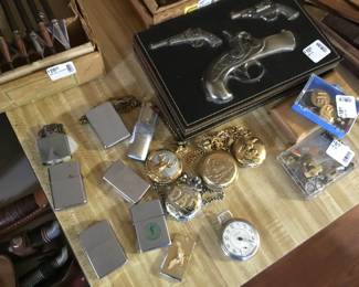 Collection of pocket watches and Zippo lighters. Also some military pins.