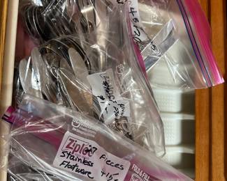 several bagged sets of stainless flatware