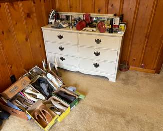Her shoes and dresser with mirror that is behind the dresser.