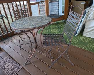 Round mosaic patio table with two metal chairs