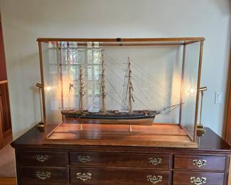 A beautiful intricate wood ship displayed in a glass case