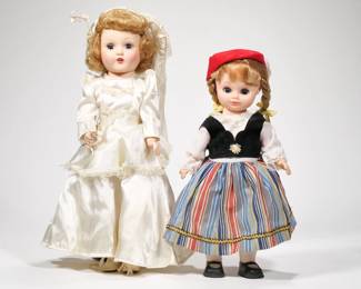 (2pc) PAIR PORCELAIN DOLLS | Includes; girl in wedding dress and girl in traditional European wear. Doll height: 15in - h. 5.5 x w. 9.5 x l. 16 in (box)