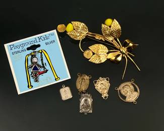 (7pc) Sterling Silver Jewelry | Including 5 sterling silver religious charms (together 0.39 ozt), a vermeil sterling pin with yellow plastic accents [two accents missing] (0.33 ozt), and a new Playground Kids sterling charm with blue and clear faux gemstones; all with fineness marks.
