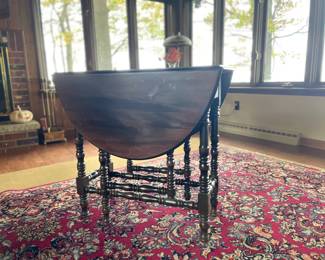 Circa 1910 walnut oval Gatelegs table with spindle legs, ideal for small spaces and holiday entertaining. This versatile space-saver can be easily opened up by raising one or both leaves, offering extra surface when needed and folding down when not in use.