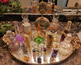 Large oval vanity mirror with assorted perfume bottles.