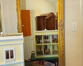 Large gold gilt mirror shows a glimpse of the interior