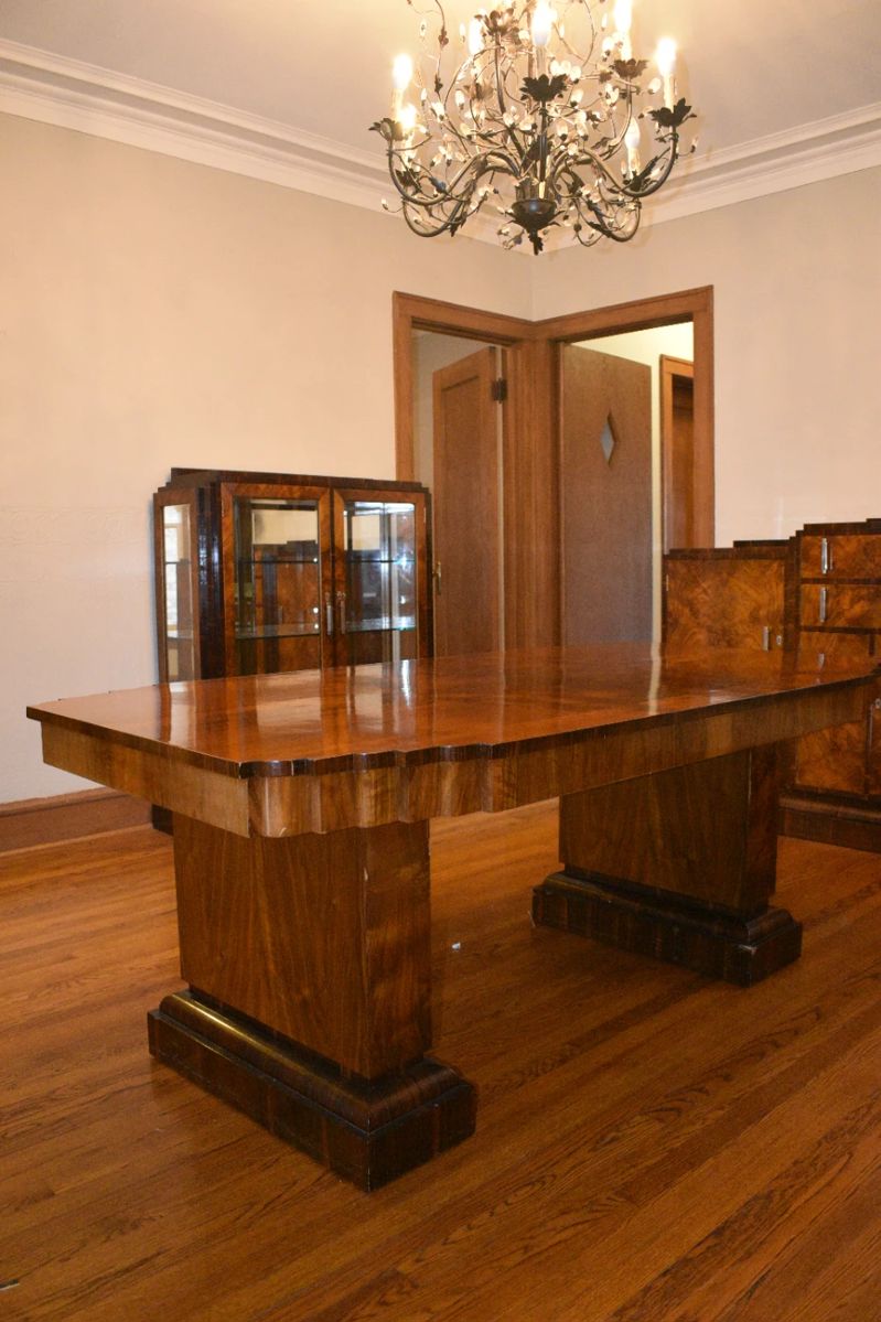 Extraordinary 1930s Art Deco dining room set by Long & Wexlear, a renowned Australian furniture manufacturer. These high-quality, handcrafted pieces captured the essence of the Art Deco movement—clean lines, geometric shapes, and streamlined elegance. The rich, figured burl wood, likely walnut or mahogany, is finished with a high-gloss lacquer—highlighting the intricate natural patterns of the wood—and the chrome hardware adds an industrial touch, further enhancing the set’s luxurious feel. Table, vitrine style display cabinet, and sideboard - there's also chairs with custom leather upholstery!