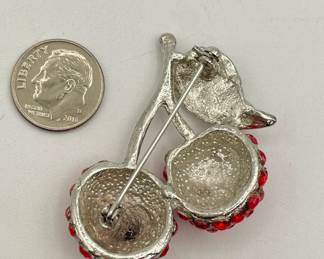 Reverse view of bright sparkling red rhinestone two cherries brooch in a bright silver tone setting