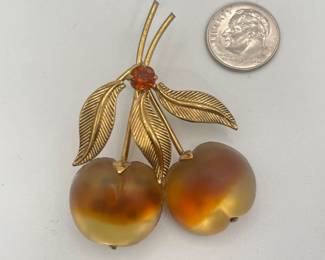 1950s Austrian brooch – bright, beautiful molded glass fruit is yellow with a stripe of orange and foil backing. There are 3 gold tone leaves connected at the center with a topaz rhinestone. The back is marked "Austria".