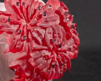Closeup of Barry Sautner art glass paperweight, carved frosted red and white glass depicting flowers and leaves