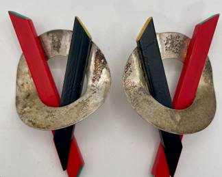 Closeup of red and black painted wood and silver circle pierced earrings (possibly sterling).