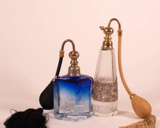 Pair of antique Art Nouveau era Moser Bohemian art glass perfume bottles with atomizer tops, one with gilt mythological warrior surround, the other a clear to blue rhomboid shape, crystal body deeply engraved with blooms and leafy stems