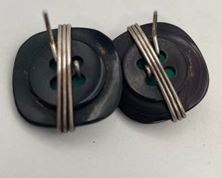 Closeup of the back of black button, turquoise color square and silver tone wire earrings