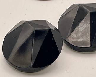 Closeup of black circular faceted clip on earrings, made in West Germany