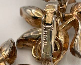 Closeup of Crown Trifari apple pendant earrings, white milk glass, gold tone metal