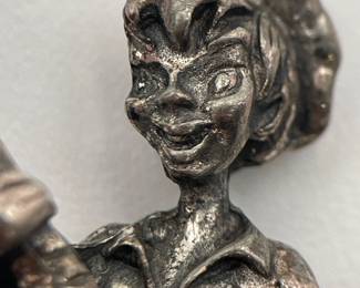 Closeup of whimsical vintage silver tone fisherman brooch, joyous young man landing a fish