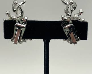 Reverse view of pair of BSK clip earrings, silver tone metal with white enamel leaf shapes and jewel cut glass pieces in pink, ice blue, and spring green