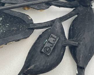 Closeup of back of vintage J.J. Jonette pears brooch, enameled metal and pavé set pale green rhinestones