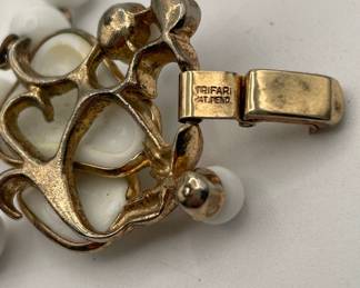 Closeup of Crown Trifari pear shape and beaded milk glass bracelet