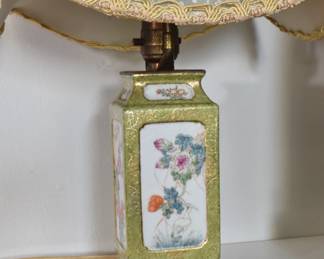 Closeup of vintage Chinese porcelain table lamp, fabric shade with dragon rondels and stylized clouds