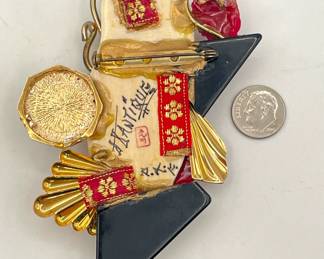 Reverse of vintage Asian maiden brooch; mixed media collage includes carved bone or resin, faux pearls, rhinestones, gold toned metal, and scarlet Bakelite or Lucite rose and fans