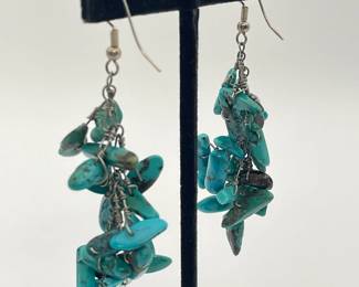 Closeup of pair of turquoise colored stone cluster dangle earrings
