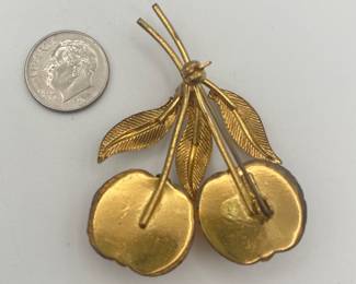 Reverse view of 1950s Austrian brooch – bright, beautiful molded glass fruit is yellow with a stripe of orange and foil backing. There are 3 gold tone leaves connected at the center with a topaz rhinestone. The back is marked "Austria".