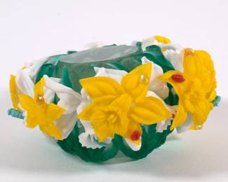 Another view of Barry Sautner art glass paperweight, clear inner sphere wreathed in green stems and white and yellow daffodil blossoms, adorned with caterpillars and insects
