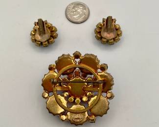 Reverse view of sparkly vintage brooch and earrings marked Made In Austria. Gold-tone metal with different shades of blue rhinestones in flower pattern