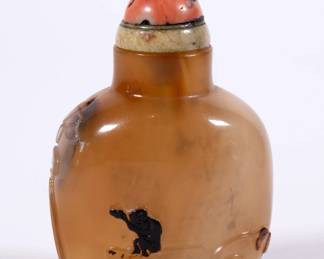 Stunning Chinese hard stone snuff bottle of compressed bulbous form with a concave lip and recessed foot, carved to display a pair of ducks swimming amidst lotus plants, with a lone monkey perched on a stylized rock, holding a peach in its upraised paw; jade and coral stopper.