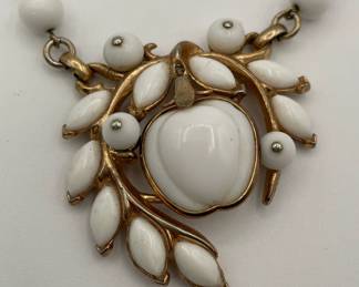 Closeup of Crown TRIFARI white milk glass apple pendant and white glass beaded necklace in gold tone metal - iconic designer piece! 